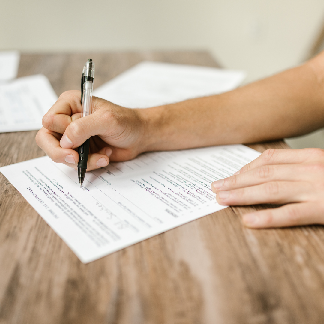 A person using a pen to fill out a form.